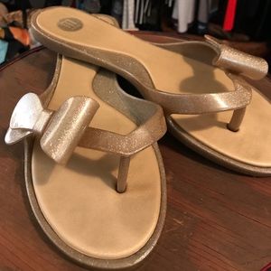 Gold Melissa rubber flip flops with bow on toe